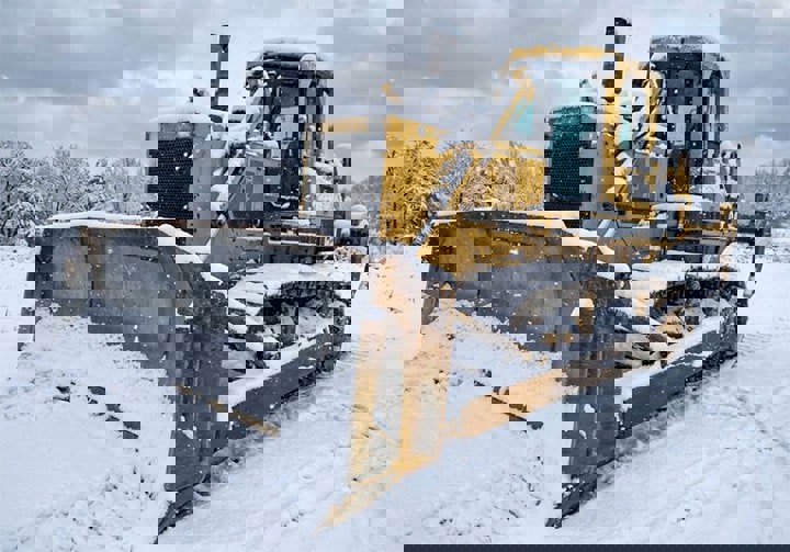 نمایی از بلدوزر در هوای برفی
